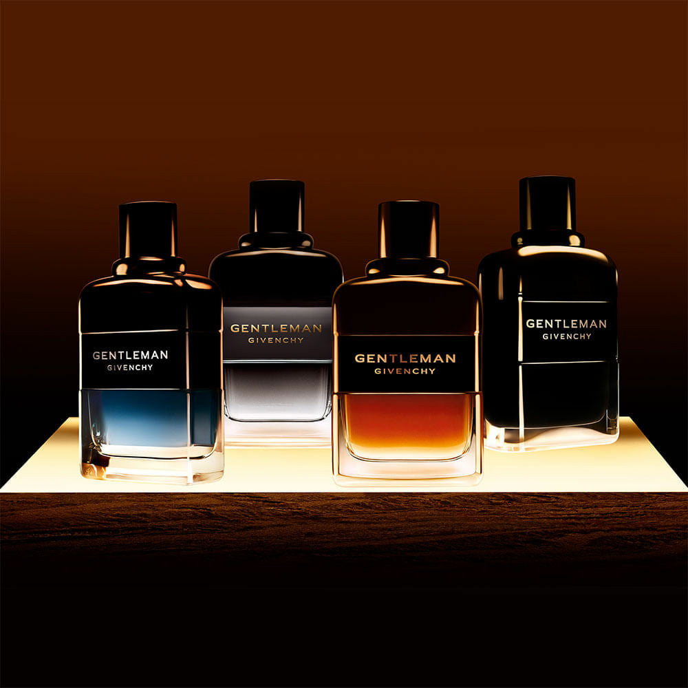 Quatro frascos da linha Gentleman Givenchy sobre uma base iluminada, com degradê de cores intensas e sofisticadas, em ambiente escuro e refinado.