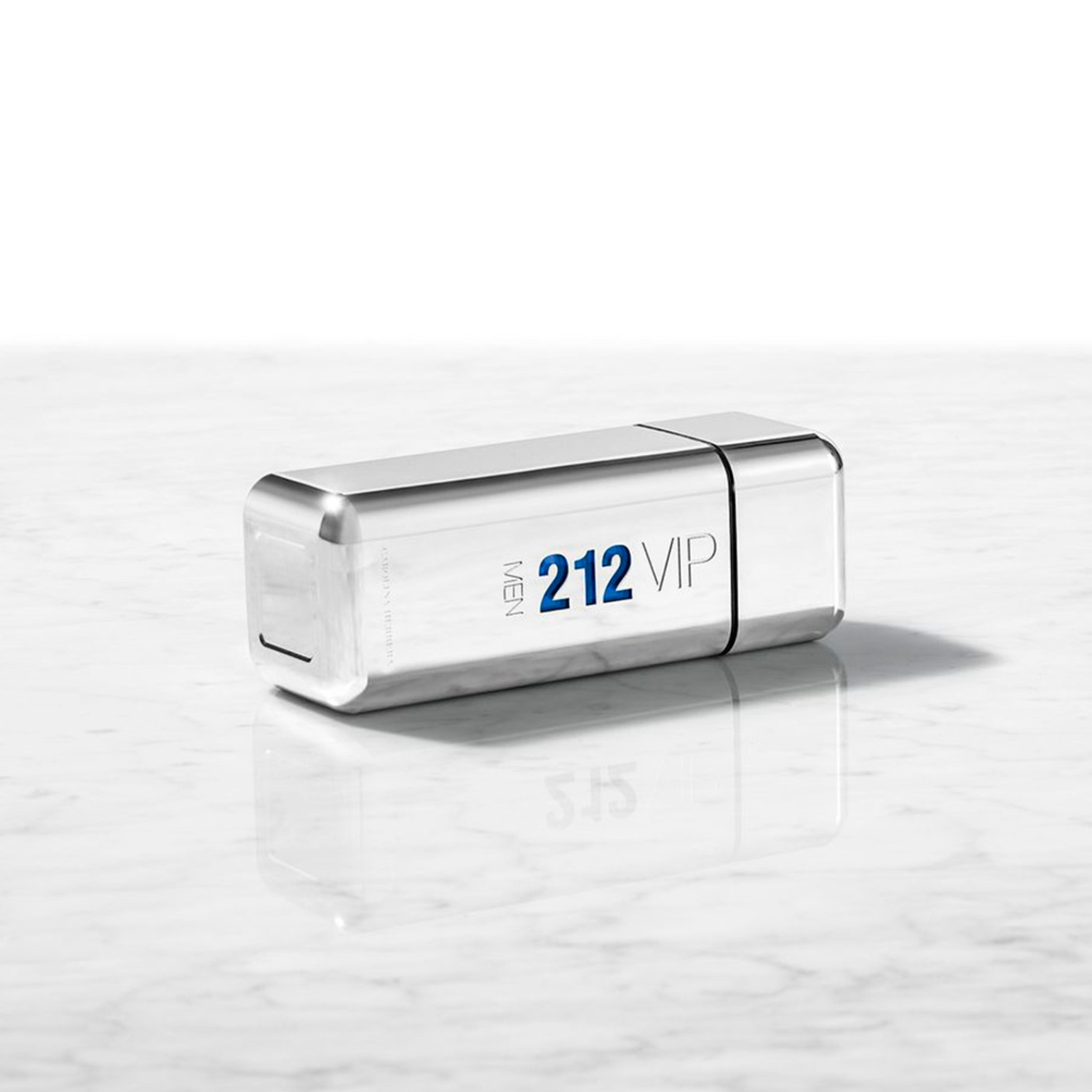 Perfume 212 Vip Men Carolina Herrera deitado sobre uma superfície de mármore branca com reflexos, transmitindo uma sensação de luxo e modernidade com seu design prateado e minimalista.