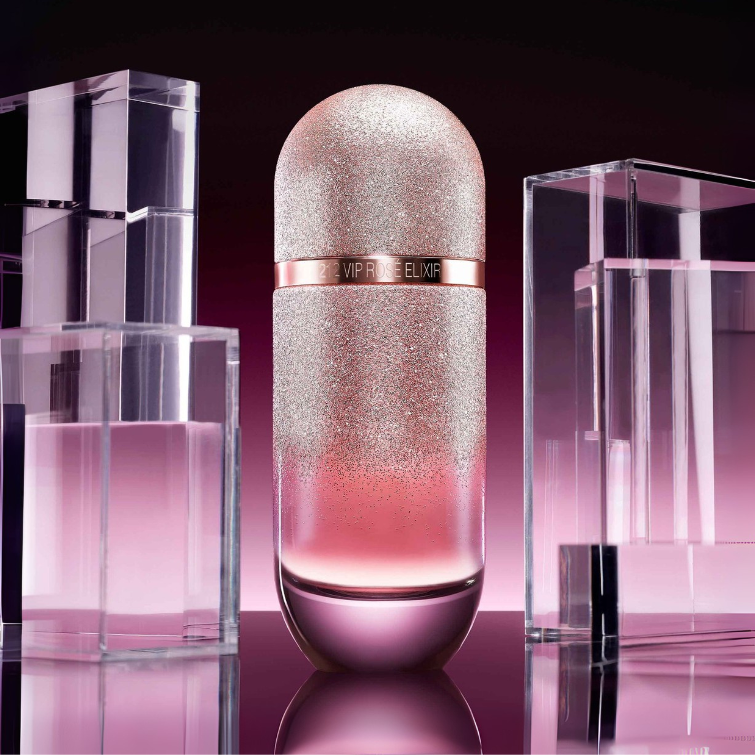 Perfume importado feminino 212 Vip Rosé Elixir Carolina Herrera em destaque sobre uma superfície reflexiva, ladeado por blocos de acrílico transparente em tons de rosa, criando uma atmosfera glamourosa e moderna, disponível na Velyre.