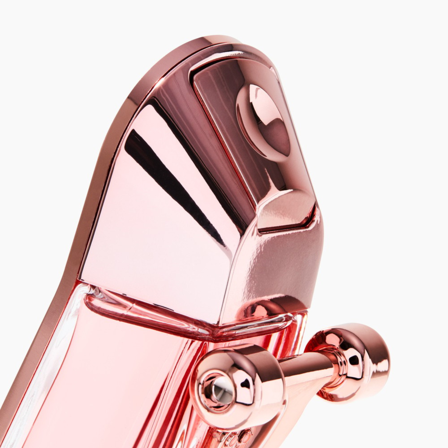 Detalhe do perfume 212 Heroes For Her Carolina Herrera, mostrando a inovadora roda de skate em ouro rosé e o acabamento metálico rosado, realçando o design único e moderno.