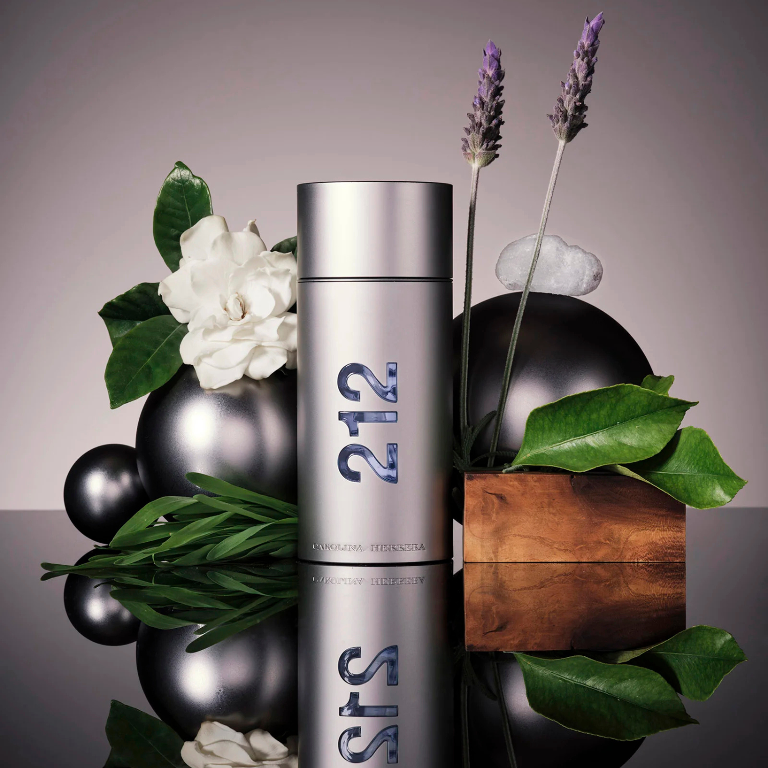 Perfume 212 NYC Men Carolina Herrera em uma composição artística com esferas prateadas, lavanda, folhas verdes e um pedaço de madeira, sugerindo uma fragrância fresca e amadeirada com um toque herbal.