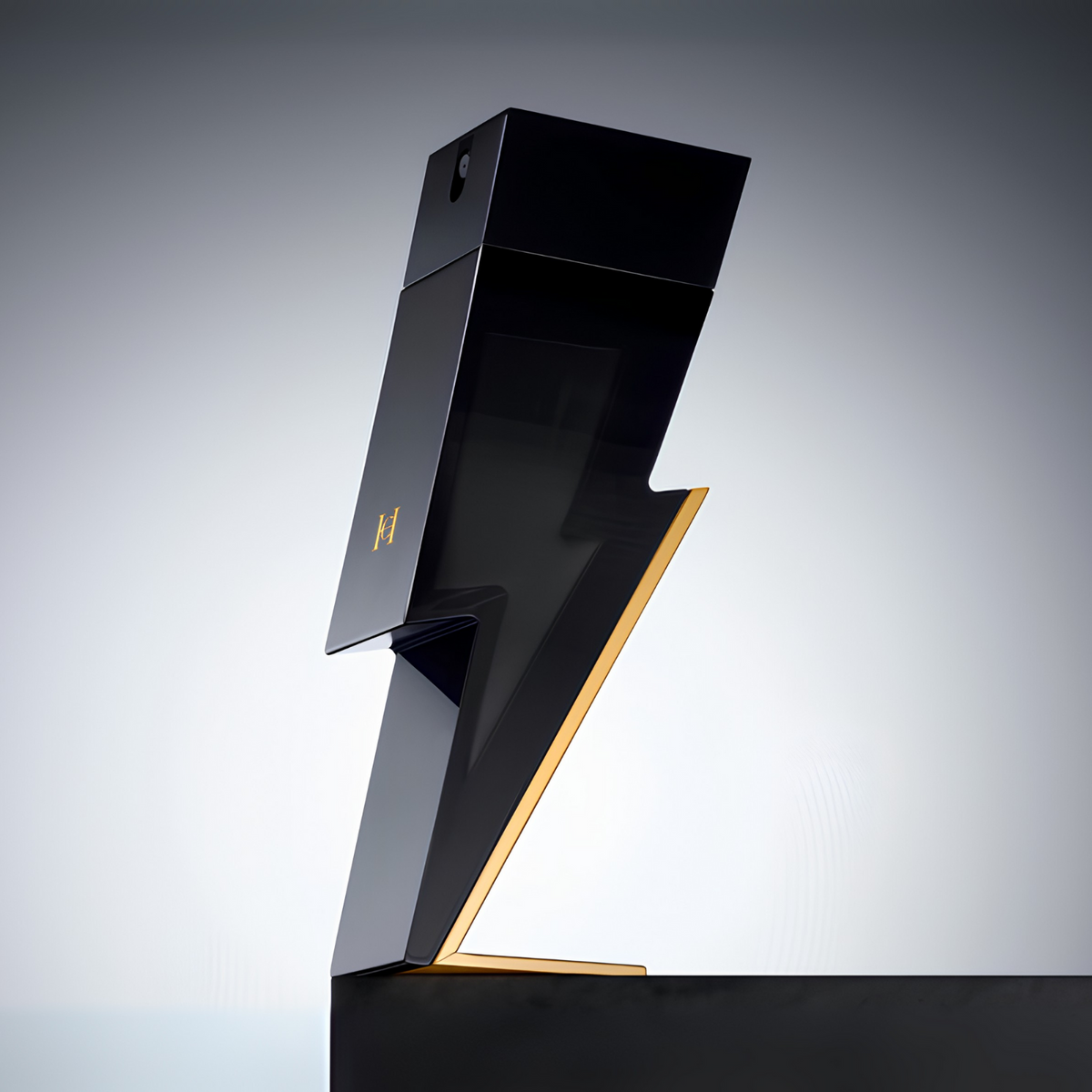 Perfume masculino Bad Boy Carolina Herrera em destaque sobre uma superfície escura com fundo claro e iluminação direcionada, realçando o design único em forma de raio e a combinação de preto e dourado.