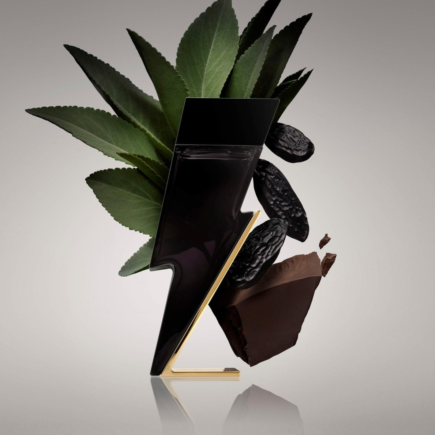 Perfume Bad Boy Carolina Herrera flutuando com folhas verdes, grãos de pimenta preta e pedaços de chocolate, sugerindo uma fragrância ousada com notas aromáticas, picantes e gourmand.