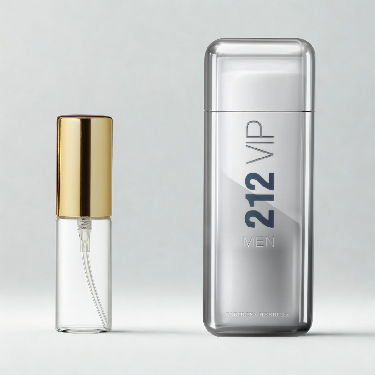 Decant de 5ml com borrifador dourado ao lado do frasco original do perfume importado masculino 212 Vip Men Carolina Herrera Eau de Toilette, ambos sobre uma superfície e fundo cinza claro. A imagem destaca a apresentação do decant para venda e a familiaridade com o frasco original, disponíveis na Velyre.