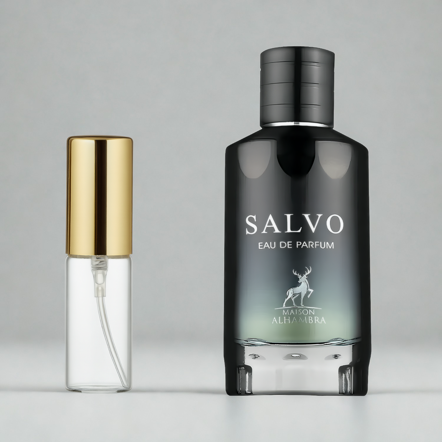 Decant de 5ml com borrifador dourado ao lado do frasco original do perfume árabe masculino Salvo Maison Alhambra Eau de Parfum, ambos sobre uma superfície e fundo cinza claro. A imagem destaca a apresentação do decant para venda e a familiaridade com o frasco original, disponíveis na Velyre.