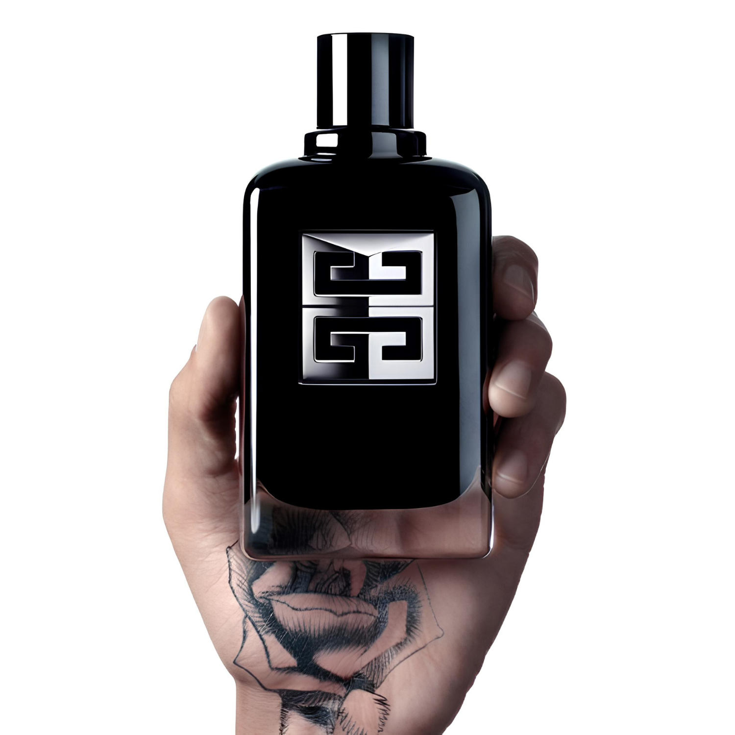 Perfume Givenchy Gentleman Society EDP sendo segurado por uma mão com tatuagem de rosa, em fundo branco.