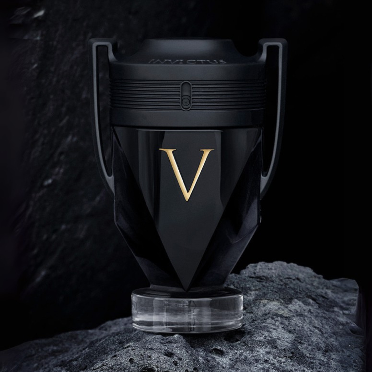 Perfume importado masculino Invictus Victory Rabanne em destaque sobre uma superfície rochosa escura, transmitindo uma sensação de poder e conquista, disponível na Velyre.