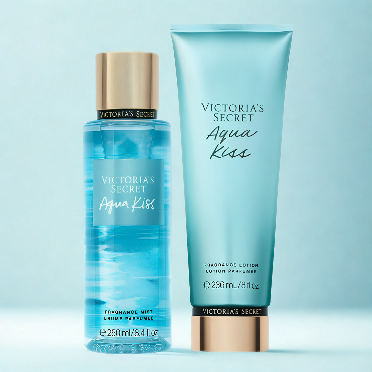 Kit de body splash e hidratante perfumado importado Aqua Kiss Victoria's Secret em close-up, disponíveis na Velyre. A imagem mostra os produtos sobre uma superfície clara e brilhante, com o fundo suavemente desfocado.