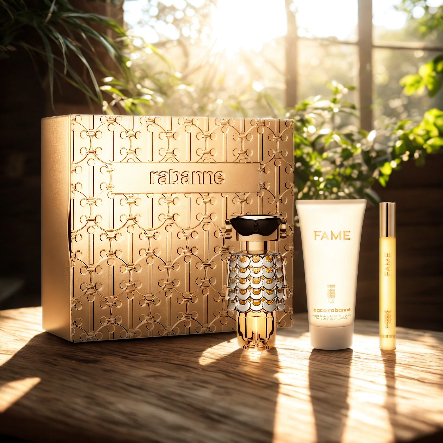 Kit feminino importado Fame Rabanne Eau de Parfum, disponível na Velyre, apresentado sobre uma superfície de madeira sob a luz do sol, destacando o frasco de robô dourado, a caneta de 10ml e o hidratante de 75ml ao lado da embalagem elegante.