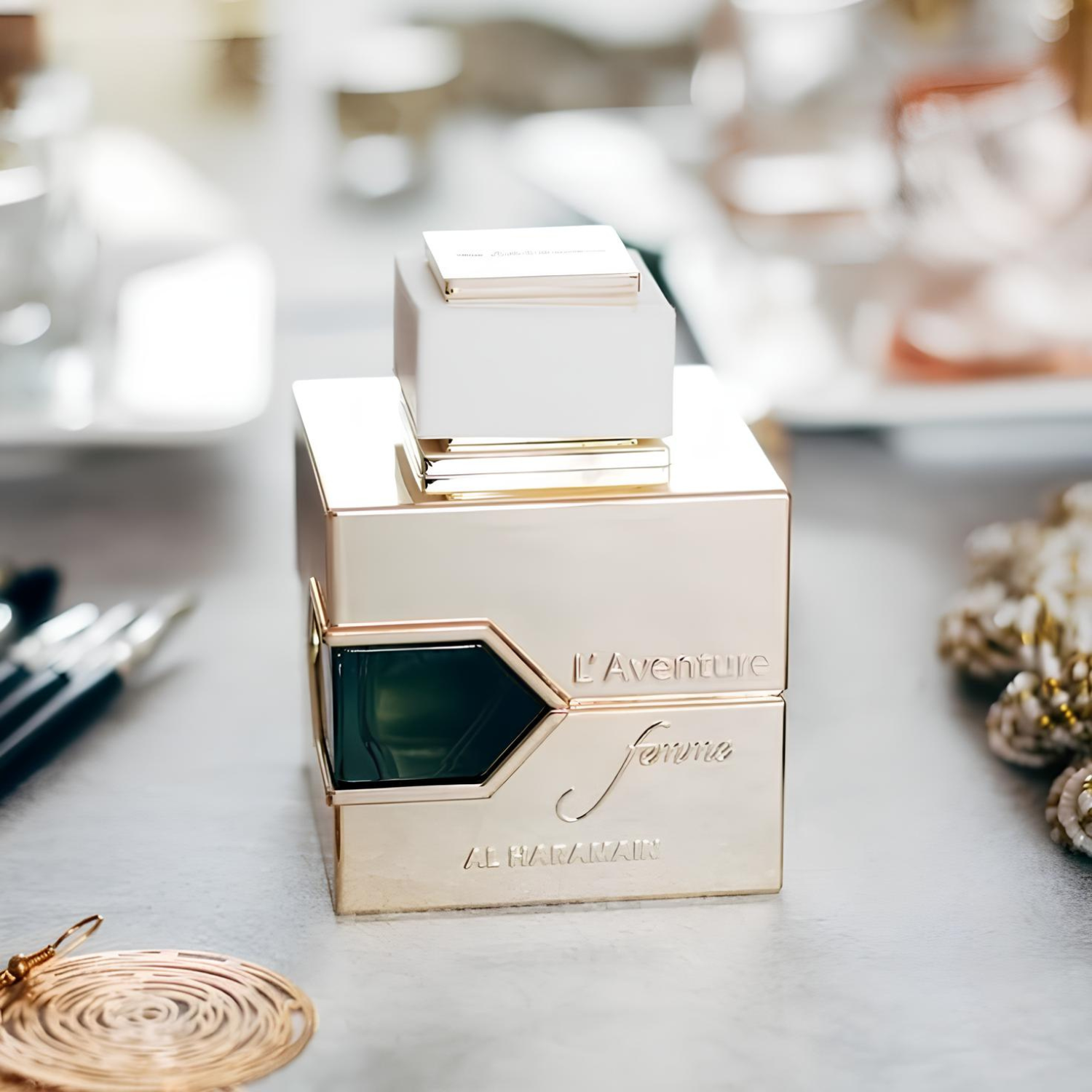 Perfume árabe feminino L'aventure Femme Al Haramain em destaque sobre penteadeira elegante com acessórios de maquiagem e joias, transmitindo feminilidade e sofisticação, disponível na Velyre.