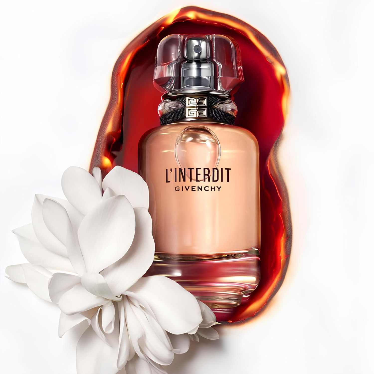Frasco do L’Interdit Givenchy em meio a uma flor branca e um fundo com efeito de cera derretida em tons alaranjados.