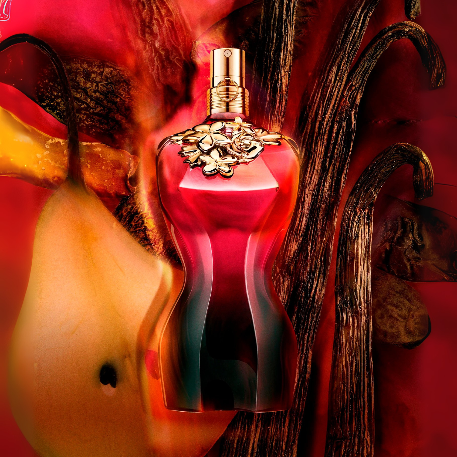 Close-up do frasco do perfume La Belle Le Parfum Jean Paul Gaultier em um fundo avermelhado, com uma pera amarelada e favas de baunilha, sugerindo notas frutadas e orientais da fragrância.