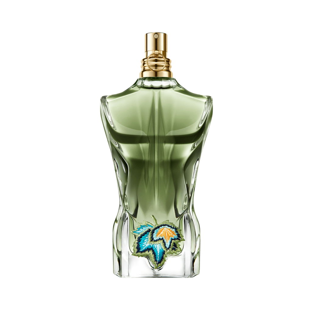 Frasco do perfume Le Beau Paradise Garden de Jean Paul Gaultier em fundo transparente. O frasco verde em formato de torso masculino traz um bordado de folhas tropicais coloridas na parte inferior, com vaporizador dourado.