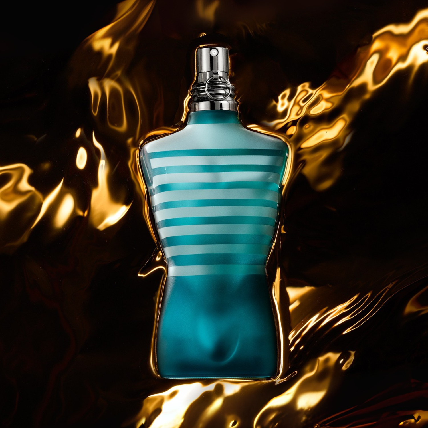 Frasco do Le Male Jean Paul Gaultier envolto em reflexos dourados luminosos, criando uma atmosfera quente e sensual.