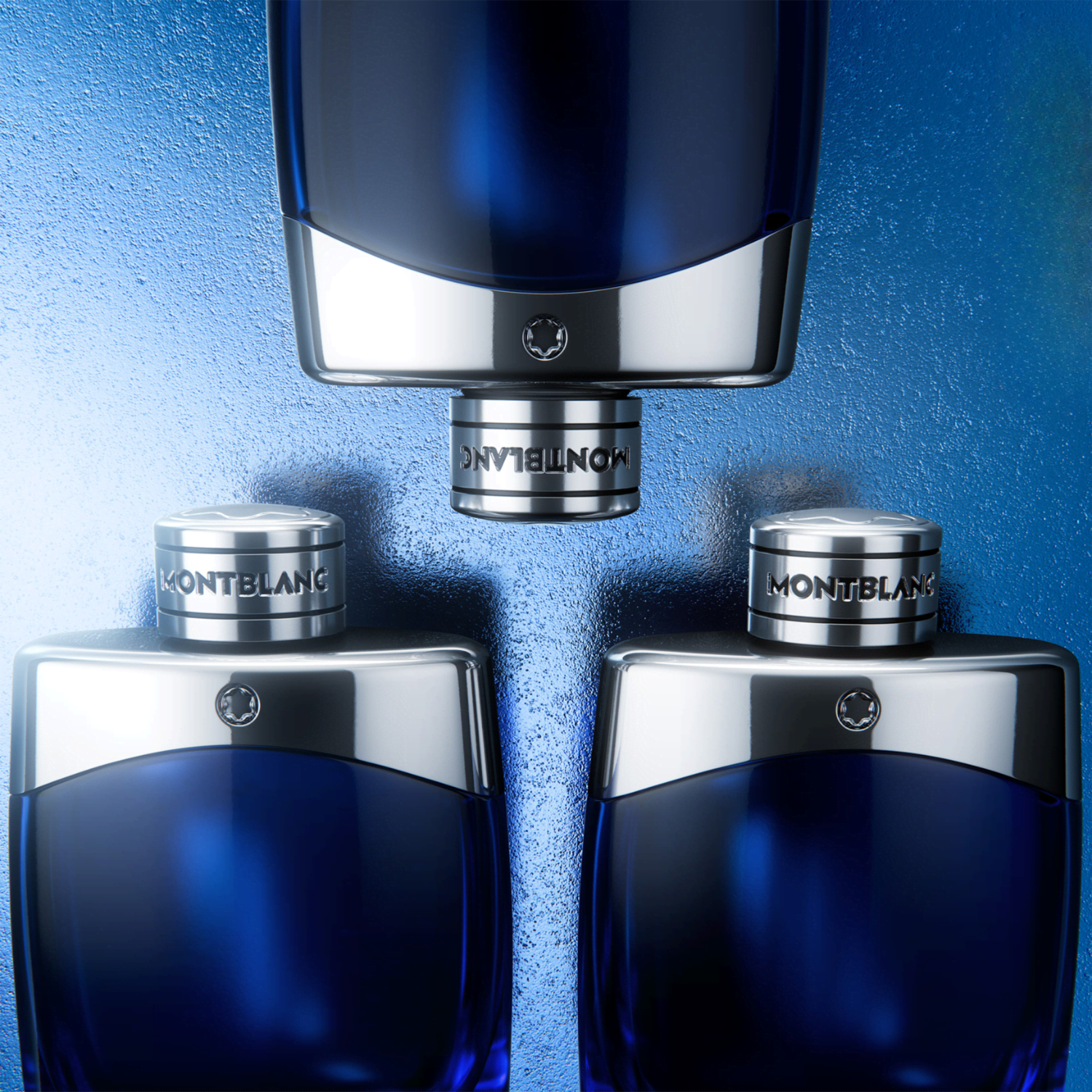 Três frascos do perfume Legend Blue Montblanc alinhados com uma luz de neon branca em forma de "M" estilizada ao fundo, transmitindo modernidade e a identidade da marca.