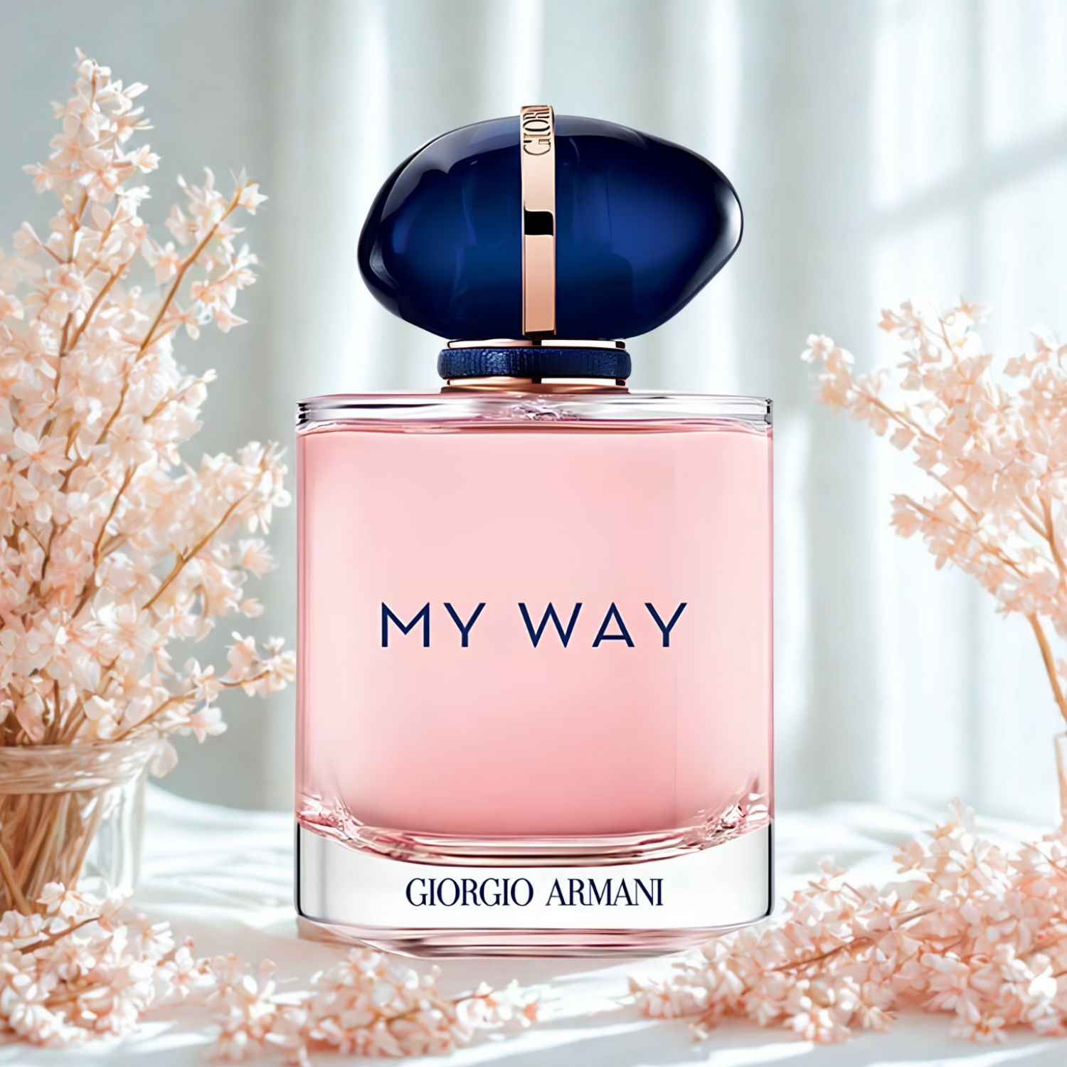 Perfume feminino My Way Giorgio Armani em destaque em um ambiente delicado com flores pequenas e rosadas, sobre um tecido branco texturizado, evocando uma fragrância floral e elegante.