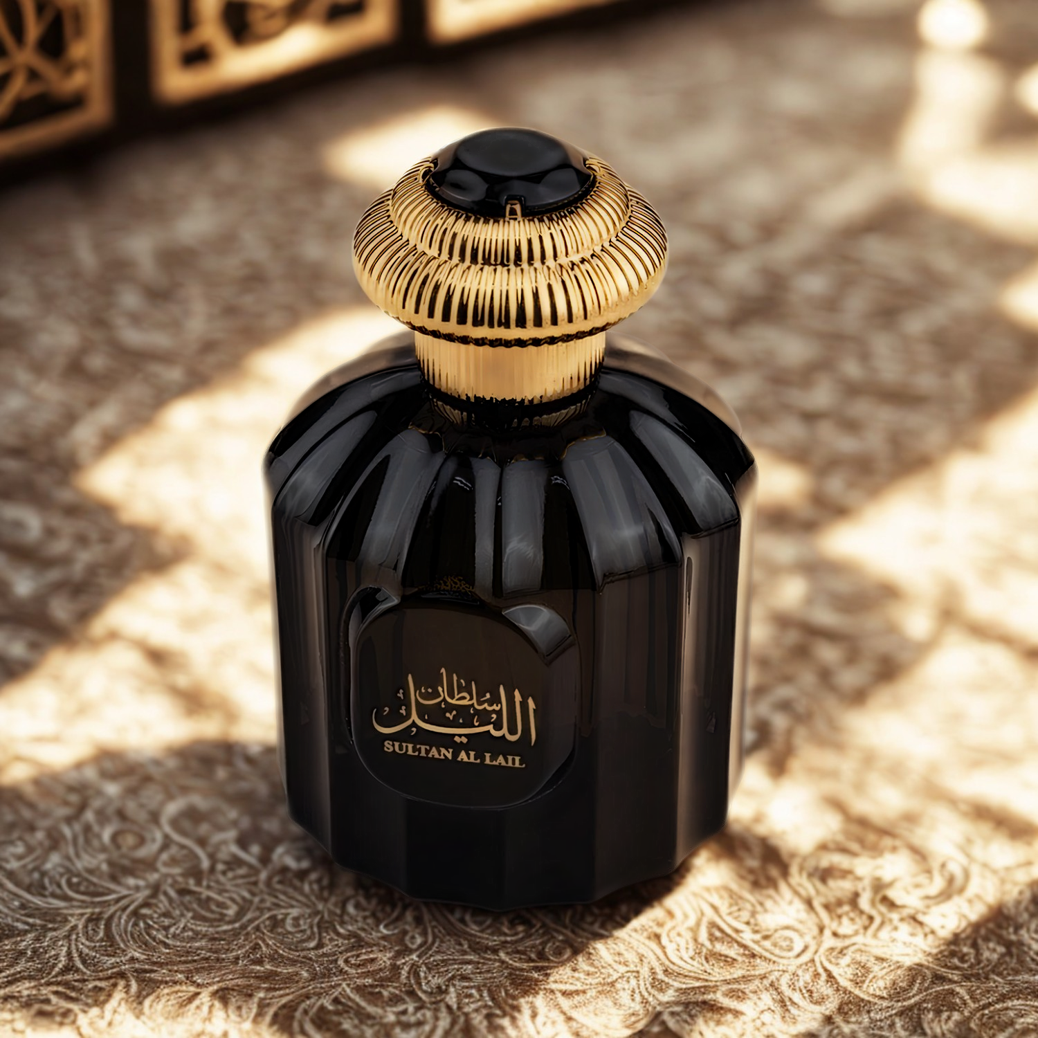 Perfume árabe Sultan Al Lail Al Wataniah, disponível na Velyre, sobre tecido com estampa em tons de bege e dourado, sob luz suave que realça os detalhes do frasco e transmite requinte oriental.