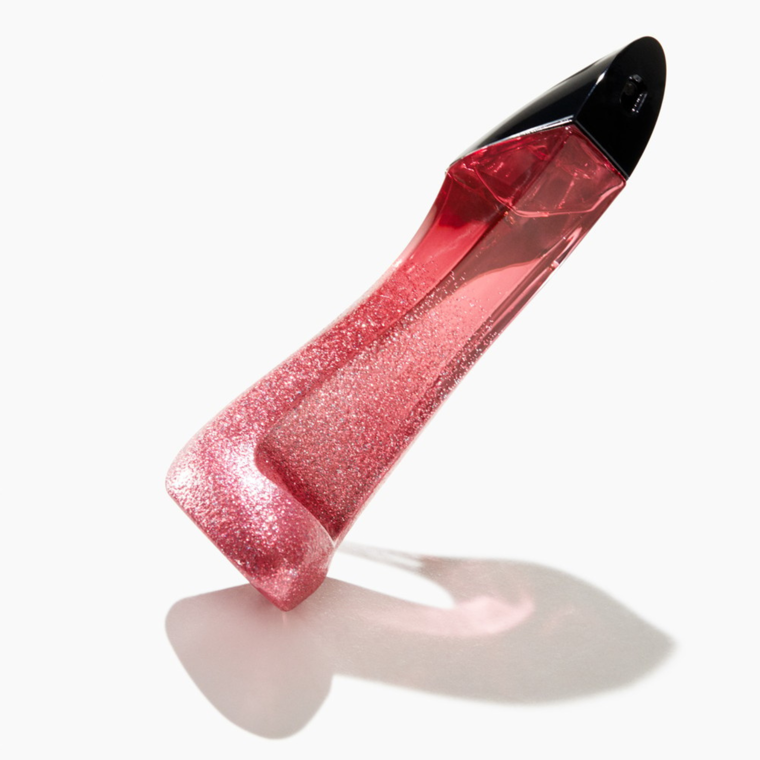 Perfume importado feminino Very Good Girl Glam Carolina Herrera inclinado sobre uma superfície branca com uma sombra projetada, realçando o formato único do sapato e o brilho do glitter vermelho, disponível na Velyre.